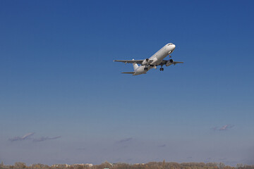 Airplane taking off from the airport. White Passenger plane fly up over runway from airport. Commercial passenger airplane takes off from the runway.