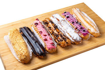 Assorted eclair cakes on a wooden board.