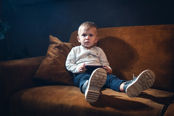 Confused Little Cute Kid on Vintage Sofa with Phone - 746082240