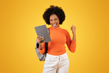 Exuberant young woman with afro hair, in an orange turtleneck and white jeans