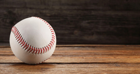 Baseball ball on wooden background, space for text