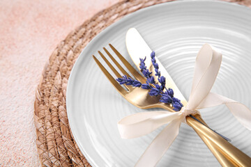 Cutlery, plate and preserved lavender flowers on color textured table, closeup. Space for text
