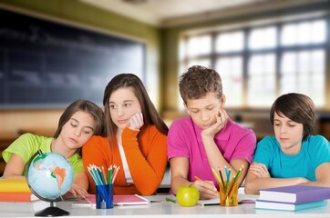 Girl and boy happy students sitting at desk