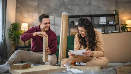young couple moving in new apartment carry assembly furniture