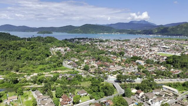 Aerial shot drone hovers in static wide shot of Paraty on sunny day