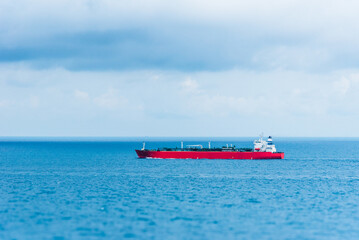 Tanker ship, sailing through calm, blue ocean. She is transporting cargo on her international trade route. 