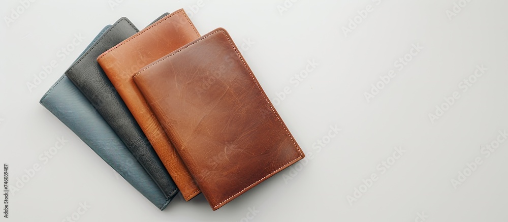Poster three leather wallets of different colors are neatly stacked on top of each other. the wallets are p