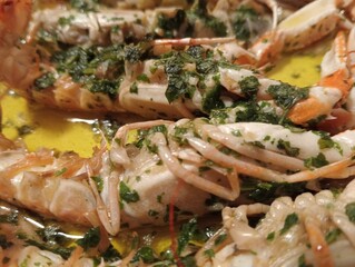 grilled prawns with oil and parsley on a plate
