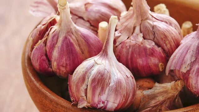 Gyration old garlic on a bowl on a wooden table background.