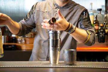 Barman prepara cokctail mimosa sobre la barra de un cocktail bar nocturno exclusivo muy delicioso