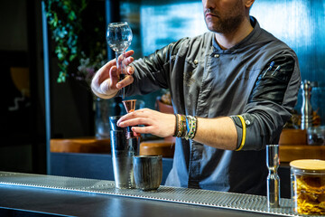 Barman prepara cokctail mimosa sobre la barra de un cocktail bar nocturno exclusivo muy delicioso