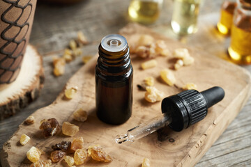 A bottle of frankincense essential oil with boswellia resin and a dropper