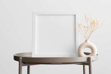 White square frame mockup with a gypsophila decoration on the beige table.