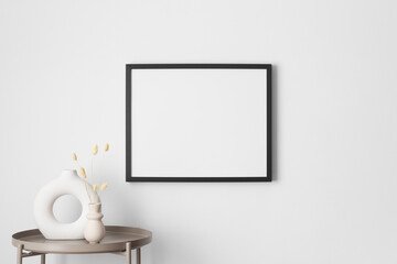 Black frame mockup on the wall with a lagurus decoration.