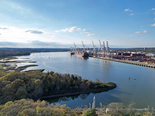 Aerial view of Southampton container terminal near river delta in Hampshire, UK. Cranes unloading...