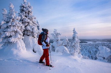 Woman snowshoeing on snowy mountain in Lapland Finland