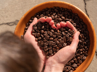 coffee beans in hands making the shape of a heart, love coffee concept