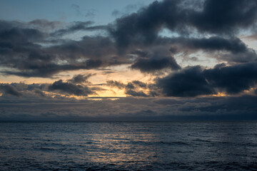 Embrace the tranquility of dawn's early light over Trinity Bay in Far North Queensland, as golden hues dance upon serene waters, painting a mesmerizing coastal scene.
