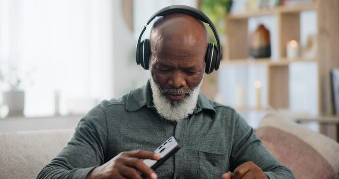 Phone, music and dance with senior black man on sofa in living room of retirement home to relax. Radio, streaming and headphones with elderly person listening to audio on mobile app in apartment