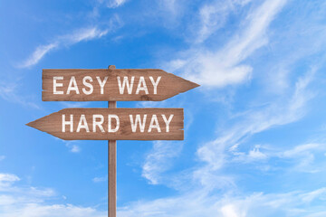 Crossroad signpost saying easy way and hard way concept for choice, confusion or decisions.