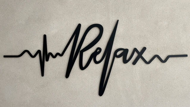 Palabra RELAX con tipograf&iacute;a electrocardiograma sobre pared de cemento con textura, toma horizontal