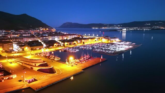 Dusk lights and fishing boats in the fishing village of Santo&ntilde;a in the Marismas de Santo&ntilde;a, Victoria y Joyel Natural Park. Cantabrian Sea. Santo&ntilde;a, Cantabria, Spain, Europe