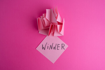 Lottery ticket with the word winner on a colored background near sheets of paper. Winner concept
