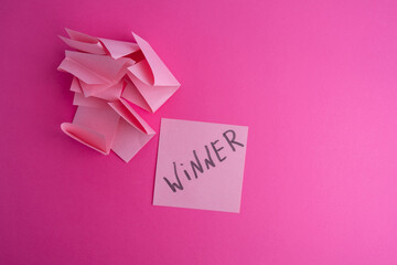 Lottery ticket with the word winner on a colored background near sheets of paper. Winner concept
