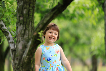 Happy little girl playing under fruit trees