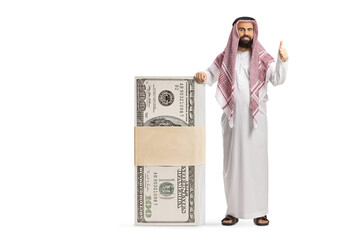 Bearded saudi arab man leaning on a stack of money and gesturing thumbs up
