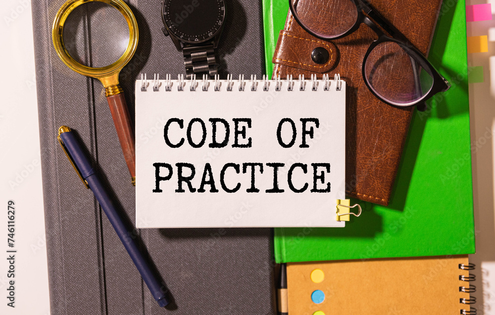 Poster code of practice text written on a notebook with pencils
