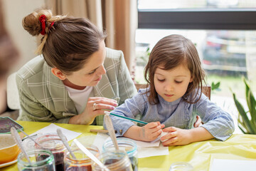 Fototapeta premium Mother Teaching Daughter Easter Egg Painting. Easter concept.