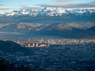 Rayon de soleil sur les trois tours de Grenoble avec le massif de Belledonne en fond