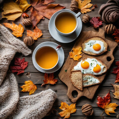 Closeup photo of a nutritious breakfast spread across a rustic wooden board. Scattered autumn leaves and a cozy hand-knit scarf suggest a crisp fall morning.
