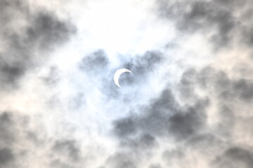 solar eclipse on a cloudy day  - obrazy, fototapety, plakaty