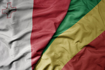big waving national colorful flag of republic of the congo and national flag of malta.