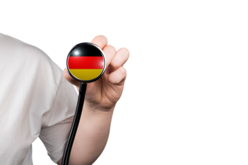 The head of a medical stethoscope in the form of the German flag in a hand (close-up) on a transparent background. German healthcare system concept