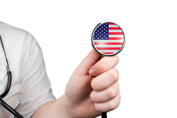 The head of a medical stethoscope in the form of a US flag in a hand (close-up) on a transparent background. US healthcare system concept - obrazy, fototapety, plakaty
