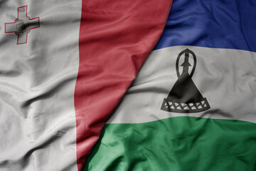 big waving national colorful flag of lesotho and national flag of malta.
