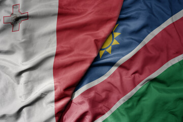 Obraz premium big waving national colorful flag of namibia and national flag of malta.