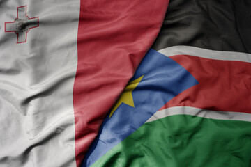 big waving national colorful flag of south sudan and national flag of malta.
