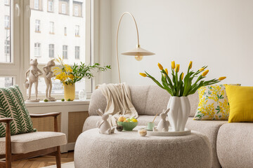 Interior design of spring living room with design sofa, furniture, vase with tulips, easter decorations, pillows and personal accessories. Home decor. Template. Easter holidays. - Powered by Adobe