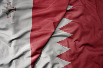 big waving national colorful flag of bahrain and national flag of malta.