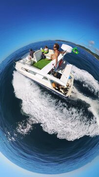 Boat with passengers move in the open sea during sunny day. Spherical little planet projection