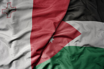 big waving national colorful flag of jordan and national flag of malta.