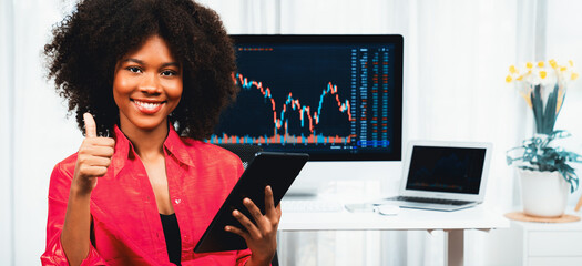 Analytical young African American businesswoman, a specialist in successful stock exchange trading,...