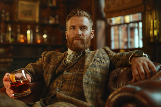 scottish man sitting with a glass of whisky in a pub