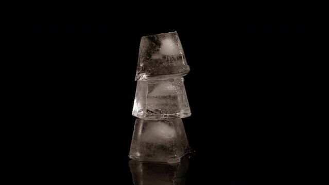 Pyramid from ice cubes on black. A view of frozen pyramide from cubes of ice on the black background.