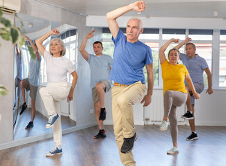 Enthusiastic elderly man attending group choreography class, learning modern dynamic dances. Concept of active lifestyle of older generation ..