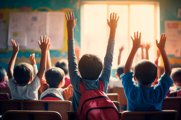 Classroom Curiosity: A captivating scene unfolds as children, seen from the back, enthusiastically raise their hands in the classroom to participate, learn, and satisfy their boundless curiosity